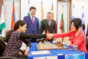 Old rivals Humpy Koneru and Hou Yifan drew their Round 1 game in front of Kirsan Ilyumzhinov. Photo © 