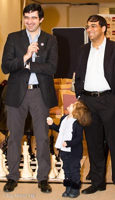 Vladimir Kramnik and Viswanathan Anand. Kramnik's daughter tries to get his attention.