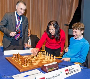 IM Malcolm Pein looks on as Member of Parliament Yasmin Qureshi makes the opening move in Luke's game against the World Champion. Photo © Ray Morris-Hill. 