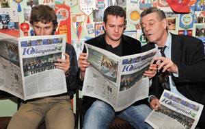 Karjakin, Bacrot and the arbiter read the newspaper bulletin. Photo © 