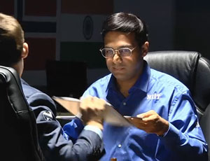 Anand exchanges score sheets after beating Carlsen in game 3. Photo &copy; 