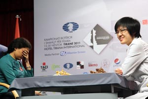 Humpy Koneru hiding her eyes from the cameras, Hou Yifan looks happy. 